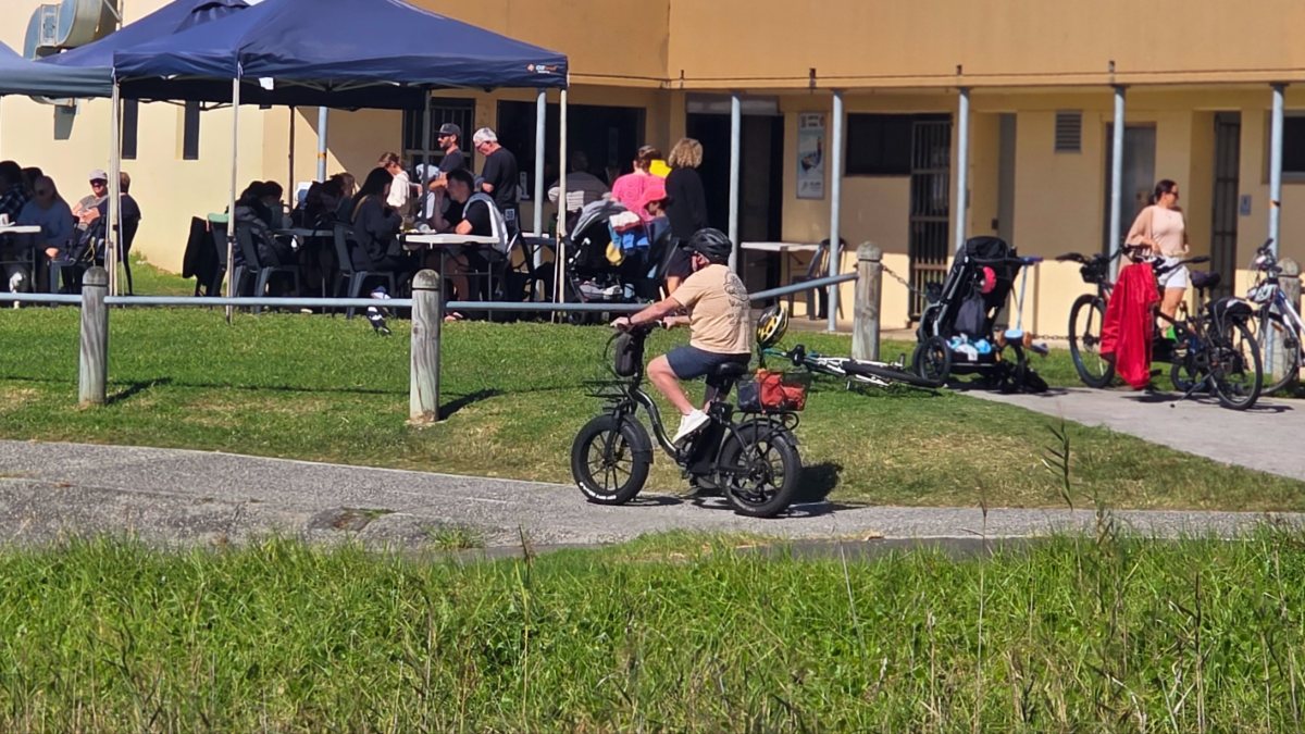 Ebike rider stopping at a café near Bellambi Beach