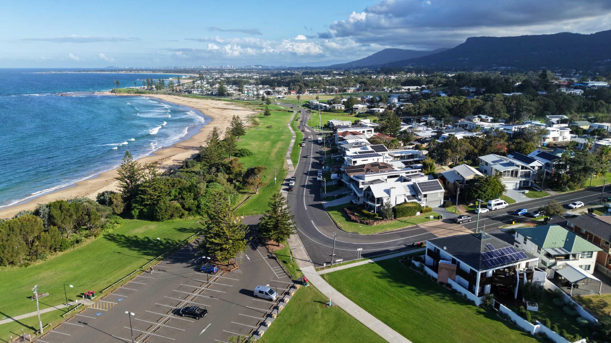 Cyclist on the Wollongong coast at Sandon Point with the Illawarra Escarpment beyond
